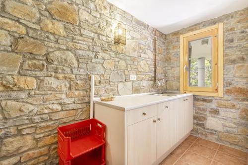 a bathroom with a sink and a stone wall at Casa Irene in Calvera