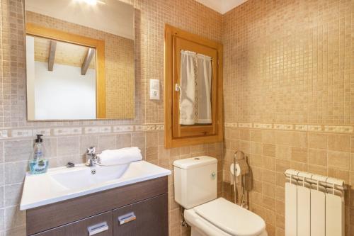 a bathroom with a toilet and a sink and a mirror at Casa Irene in Calvera