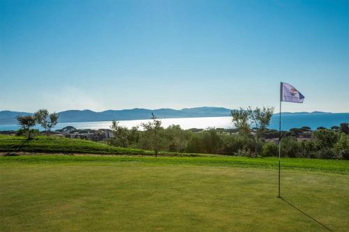 a golf course with a flag in the grass at Maremma 1851 in Follonica