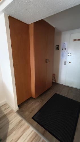 une chambre vide avec une porte et un tapis dans l'établissement Studio classé 4 personnes face aux Thermes, avec coin nuit, à Le Mont-Dore