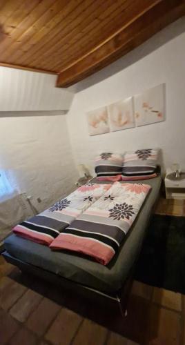 a bed sitting in a room with a wall at Hus Meeresbrise in Arrild
