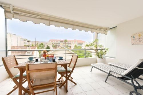 une salle à manger avec une table et des chaises et un balcon dans l'établissement 2-Br quiet location near the beach, à Cannes