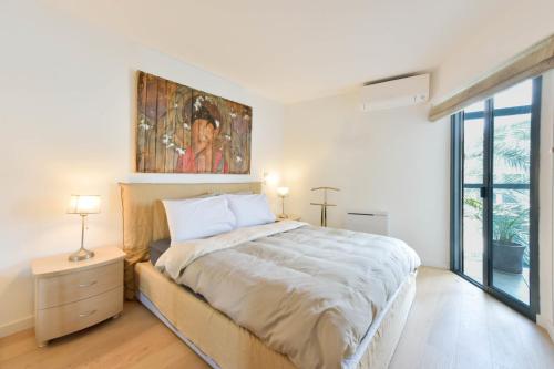 une chambre avec un lit et un tableau au mur dans l'établissement 2-Br quiet location near the beach, à Cannes