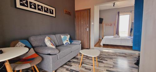 a living room with a couch and tables and a bedroom at Closer "Penthouse Apartment 1" in Thessaloniki