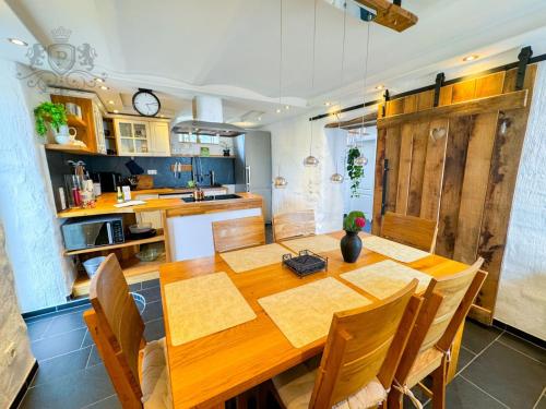 eine Küche und ein Esszimmer mit einem Holztisch in der Unterkunft Altes Backhaus in der Eifel in Feuerscheid