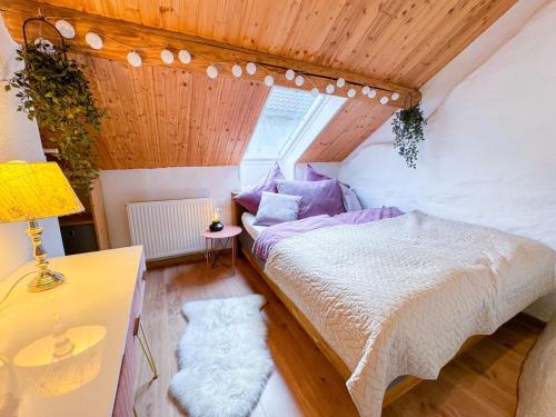 ein Schlafzimmer mit einem Bett, einem Tisch und einer Lampe in der Unterkunft Altes Backhaus in der Eifel in Feuerscheid