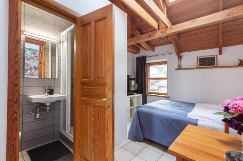łazienka z łóżkiem i umywalką w pokoju w obiekcie House of Sun w Wilnie