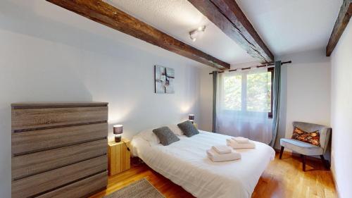 une chambre avec un lit, une chaise et une fenêtre dans l'établissement Au Petit Vauban 2 chambres & parking, à Colmar