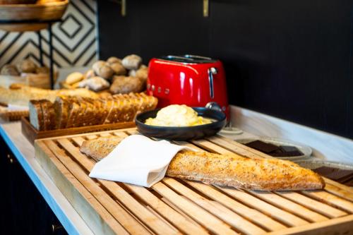 um buffet com pão e um aparelho vermelho numa mesa em ProfilHotels Copenhagen Plaza em Copenhague