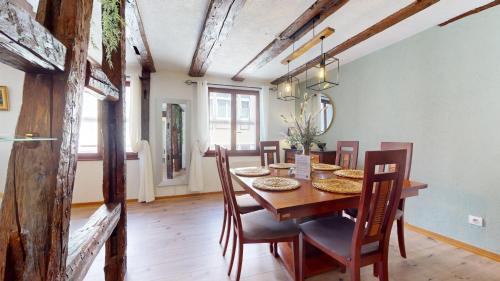 une salle à manger avec une table et des chaises en bois dans l'établissement Au Petit Vauban 2 chambres & parking, à Colmar