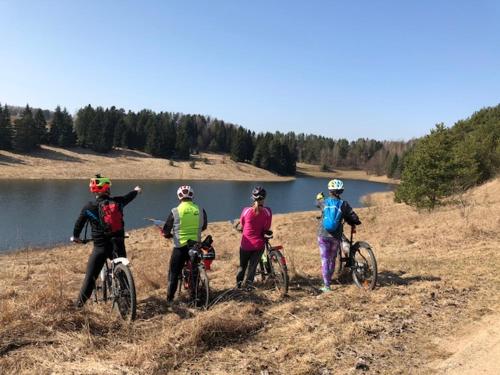 a group of people riding bikes on a hill near a lake at Pokoje w Gołdapi in Gołdap