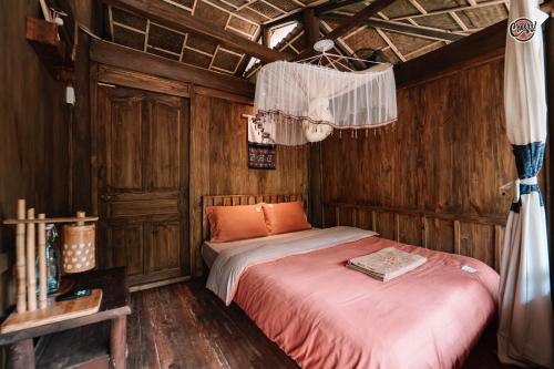 a bedroom with a bed in a wooden room at Cheers Ecolodge Du Già in Làng Cac