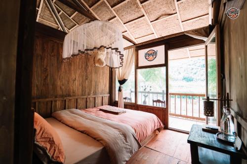 a bedroom with a bed in a room with a window at Cheers Ecolodge Du Già in Làng Cac