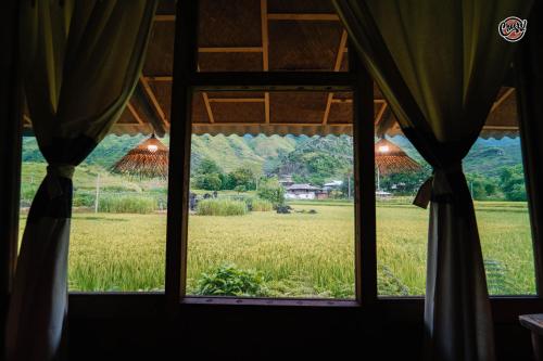 a window looking out at a field of wheat at Cheers Ecolodge Du Già in Làng Cac