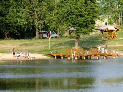 a group of people sitting on the shore of a lake at Pokoje w Gołdapi in Gołdap