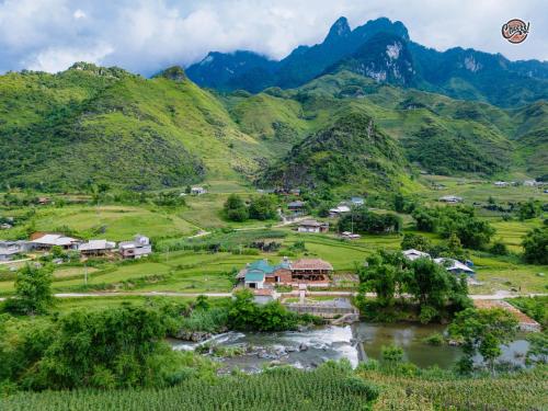 a village in the mountains with a kite in the sky at Cheers Ecolodge Du Già in Làng Cac