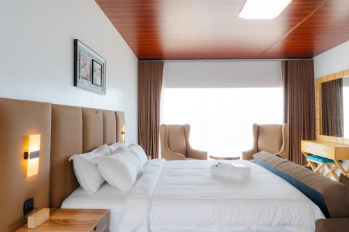 een hotelkamer met een groot bed en een bank bij Q Beach Resort in Cabangan
