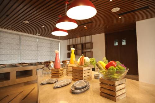 a kitchen with a table with fruits and vegetables on it at Ramada by Wyndham Gorakhpur Gorakhnath Mandir Road in Gorakhpur
