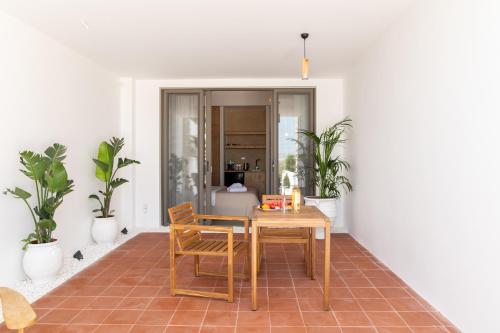 a table and chairs in a room with plants at Li Mango in Tigaki