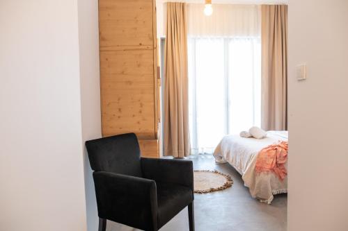 a bedroom with a bed and a chair and a window at Li Mango in Tigaki