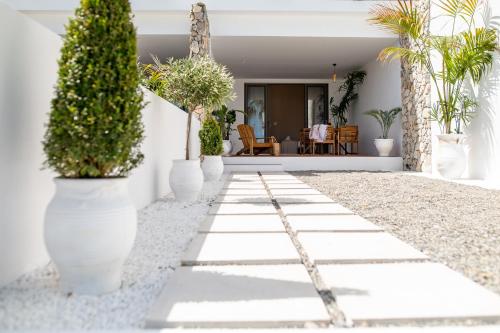 a walkway with potted plants on the side of a house at Li Mango in Tigaki