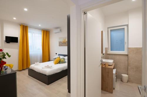 a bedroom with a bed with yellow curtains in it at Da Zia Gina Locazione Turistica in Bisceglie
