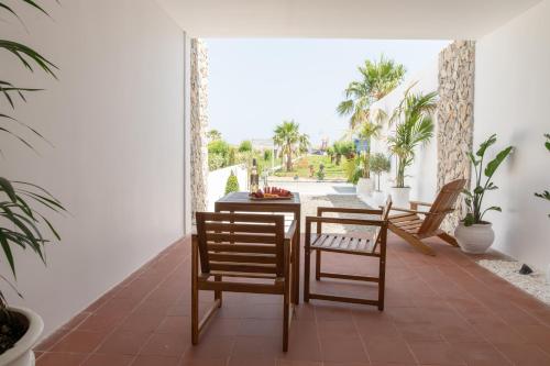 a dining room with chairs and a table with a view at Li Mango in Tigaki