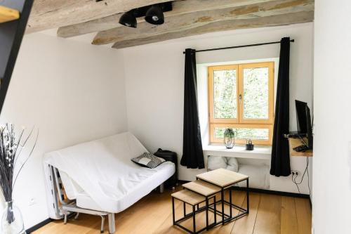 uma sala de estar com um sofá branco e uma janela em Gîte à la campagne em Fercé