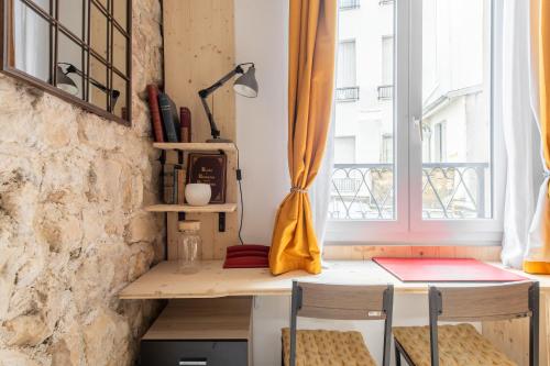 un bureau dans une pièce avec une fenêtre dans l'établissement Géranimus CLERY: Heart of Paris, à Paris