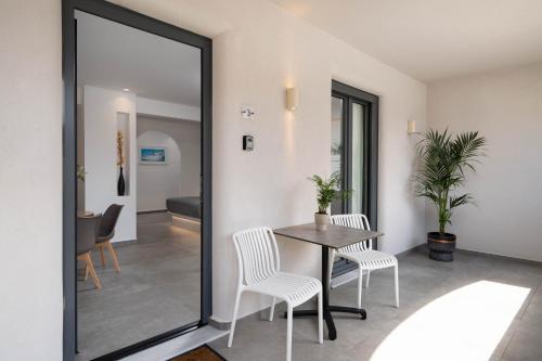 a dining room with a table and chairs and a mirror at LyMaRou Collection in Megalokhori