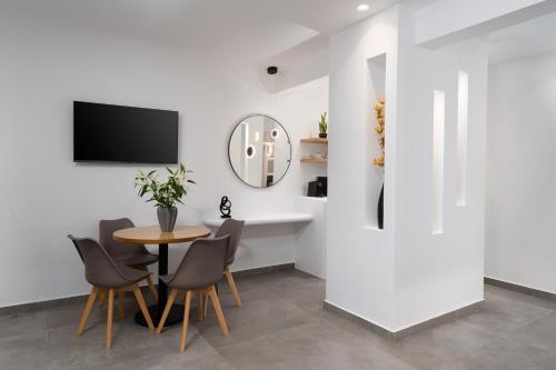 a dining room with a table and chairs and a mirror at LyMaRou Collection in Megalokhori