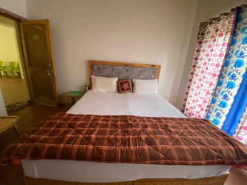 a bedroom with a large bed with a brown blanket at Wachan Guest House -Hunder in Hundar