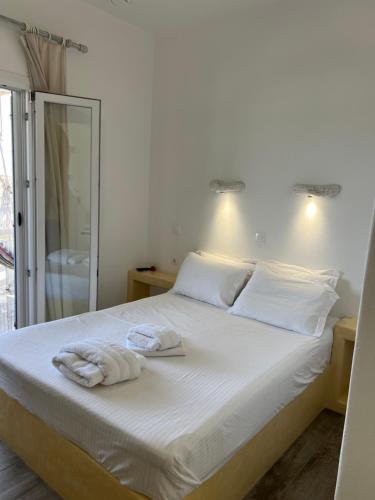 a bedroom with a bed with towels on it at Alexandra’s studios in Iraklia