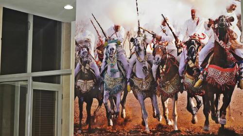 a painting of a group of men riding horses at Hotel La Place in El Jadida