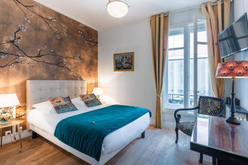 a bedroom with a bed with a painting on the wall at Hôtel Le Bretagne in Vannes