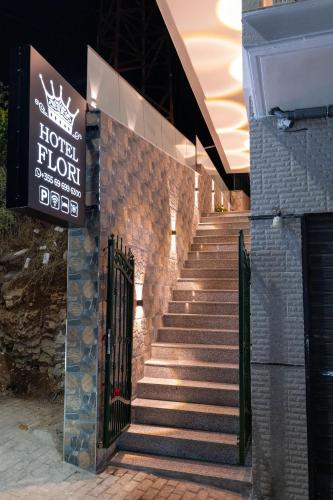 un conjunto de escaleras con un cartel en un edificio en Hotel Flori, en Sarandë