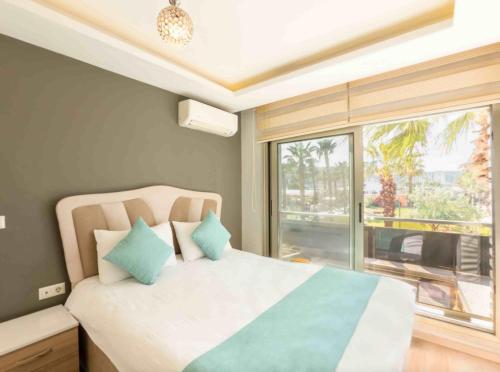 ein Schlafzimmer mit einem Bett und einem großen Fenster in der Unterkunft Sigacik Marina Apart Hotel in Siğacık