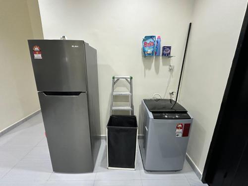a refrigerator and a trash can in a room at Rumah Menara Malay Homestay in Klang