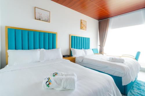 een hotelkamer met 2 bedden en handdoeken erop bij Q Beach Resort in Cabangan