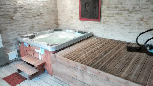 a hot tub in a room with a wooden floor at Villa de 4 chambres avec piscine privee jacuzzi et jardin clos a Chateau la Valliere in Château-la-Vallière