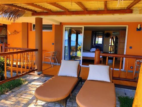 a porch with two chairs and a bed on a balcony at VILLA PANORAMA NOSY BE in Nosy Be