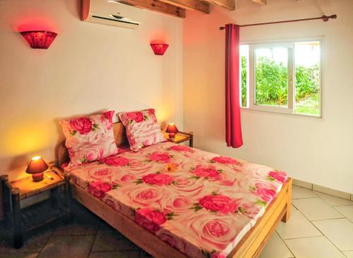 ein Schlafzimmer mit einem Bett mit Rosen darauf in der Unterkunft 4 bedrooms villa with sea view enclosed garden and wifi at Foulpointe Madagascar in Foulpointe