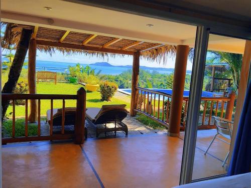a porch with a view of the ocean at VILLA PANORAMA NOSY BE in Nosy Be