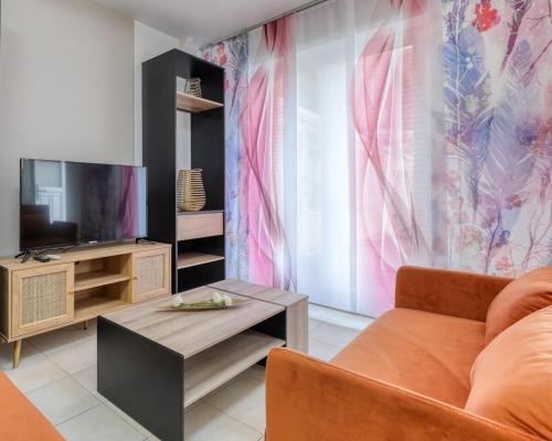 un salon avec un canapé et une télévision dans l'établissement Appartement 2pièces de 35 m2 - Rickhoss Home, à Étampes