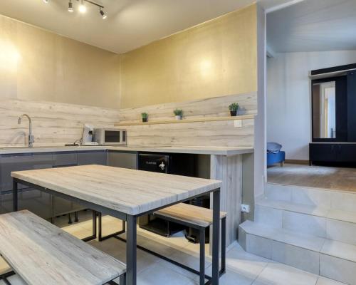 - une cuisine avec une table en bois et des bancs dans l'établissement Appartement 2pièces de 35 m2 - Rickhoss Home, à Étampes