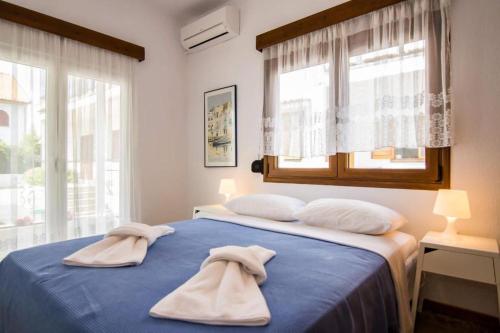 Un dormitorio con una cama azul con toallas. en Boskos Villa 2, en Nea Vrasna