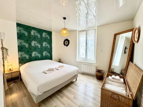 une chambre avec un grand lit blanc et un miroir dans l'établissement Le Vendays Reims plein de charme, à Reims