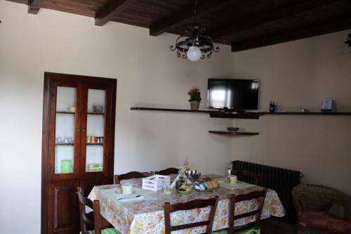 una sala da pranzo con un tavolo e una tv di La Dimora del Passato B&B a Castellone