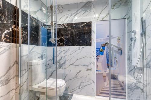 une salle de bain avec toilettes et douche en verre dans l'établissement Studio très fonctionnel - Rickhoss Home, à Samois-sur-Seine