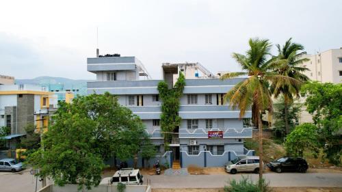 a building with a palm tree in front of it at ABS Home Stay, 2Bed room AC Flats,Tirupati in Tirupati